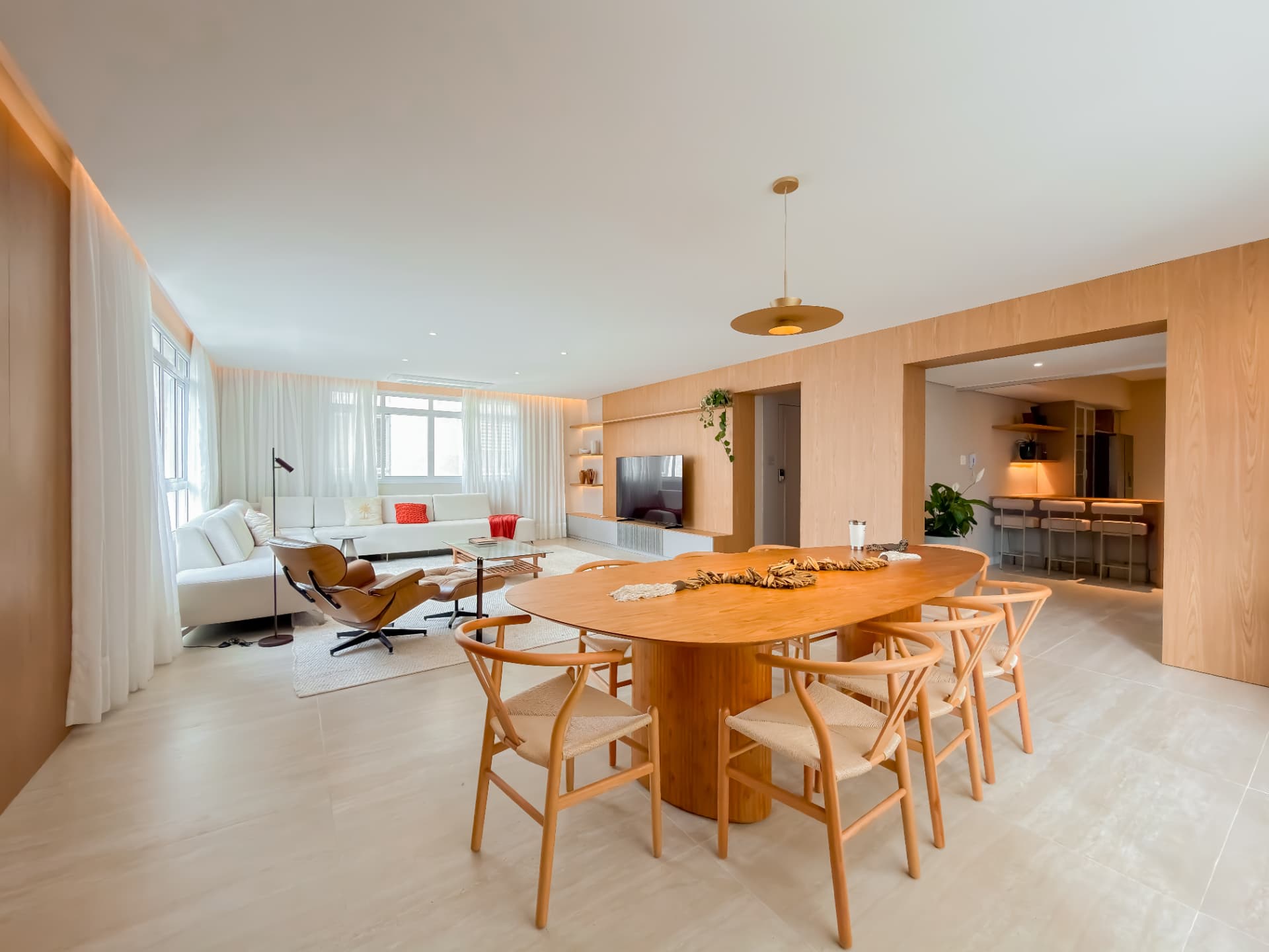 Apartamento com sala de jantar e estar integradas, acabamento em madeira clara